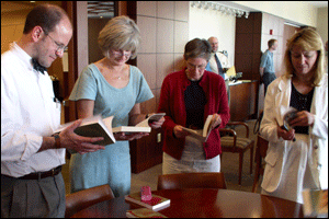 St. Olaf faculty members Jon Bruss, Sylvia Carullo, Mary Cisar, and Corliss Swain browse colleagues' books during a May 13 event recognizing St. Olaf faculty published during the past year.